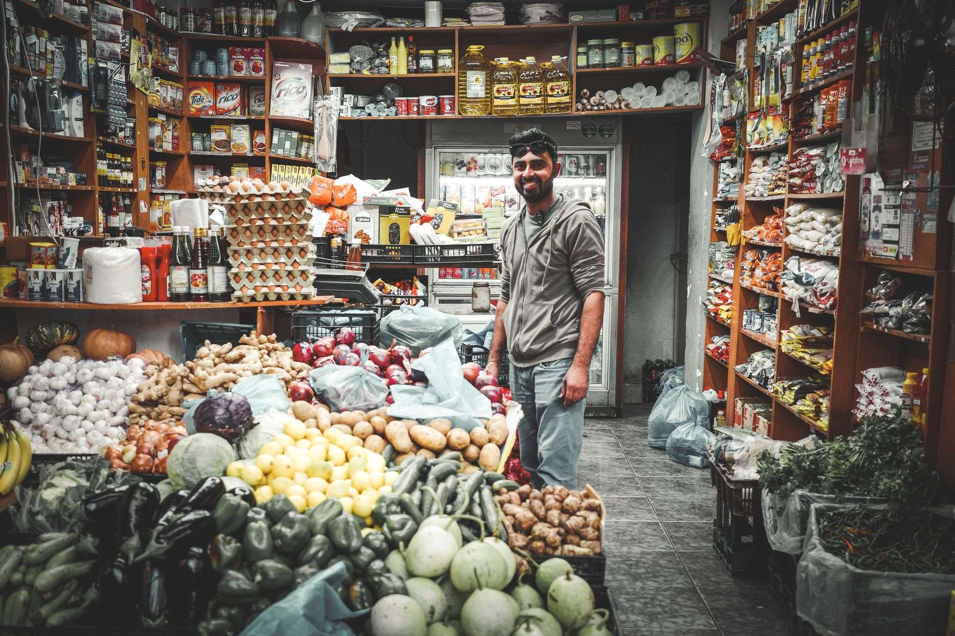 Shelves of packaged goods and produce inside a small neighborhood grocery store