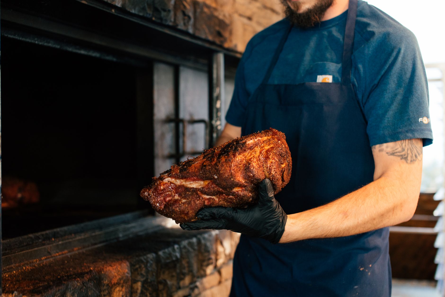 A plate of smoked pulled pork and ribs with Southern sides