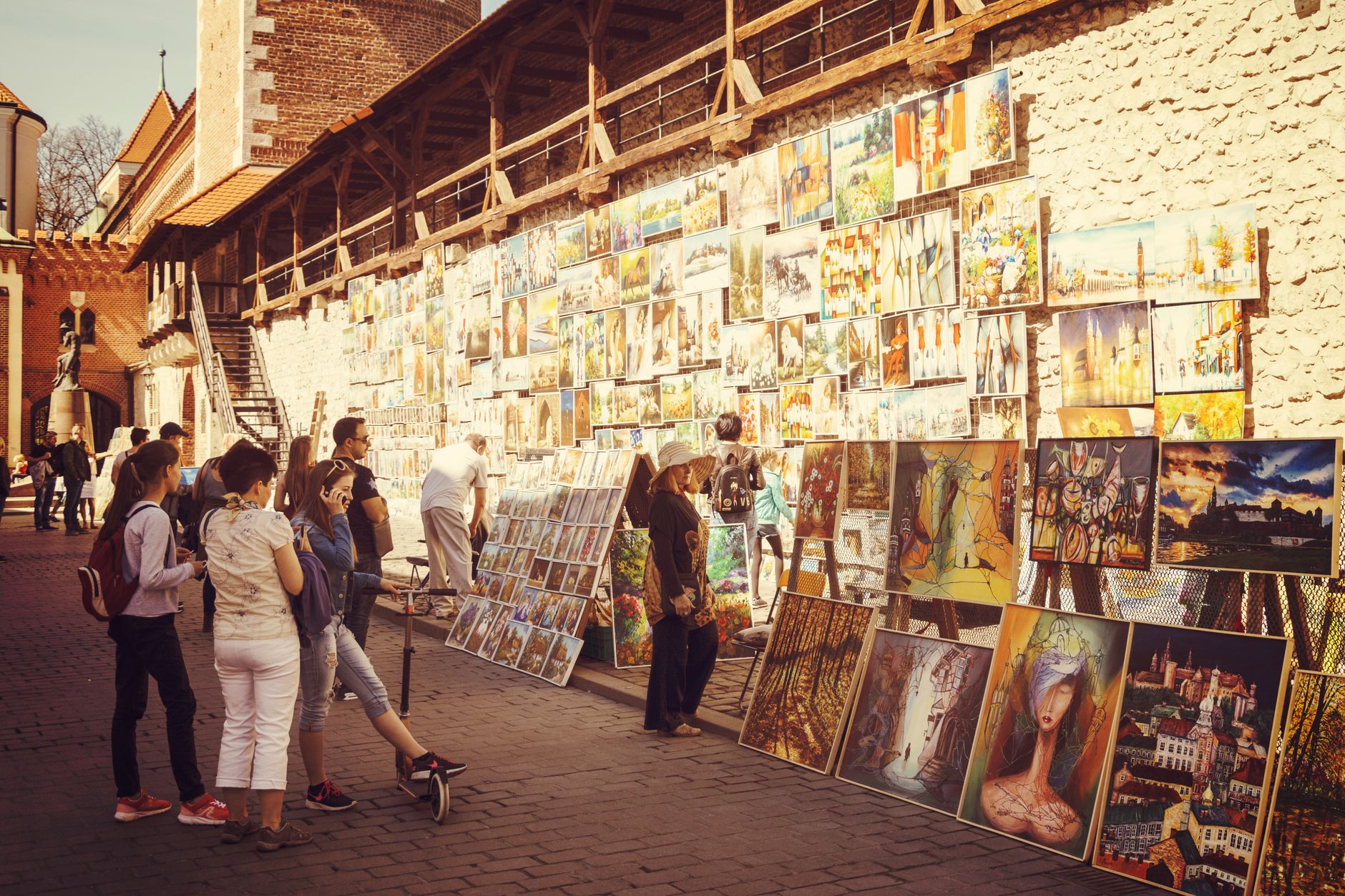 People viewing paintings on the walls of an art gallery during an evening event