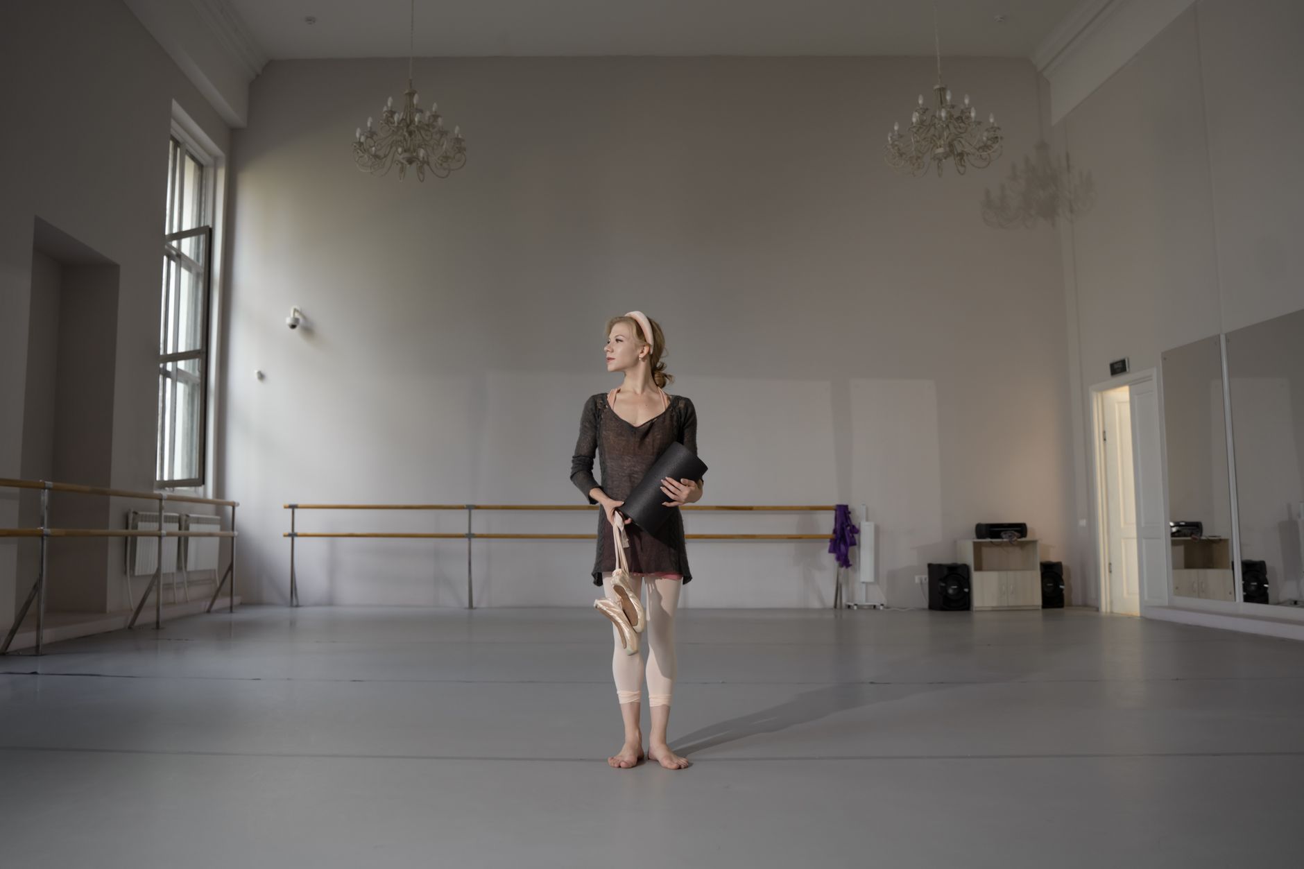 A ballet dancer in pointe shoes practicing in a sunlit dance studio