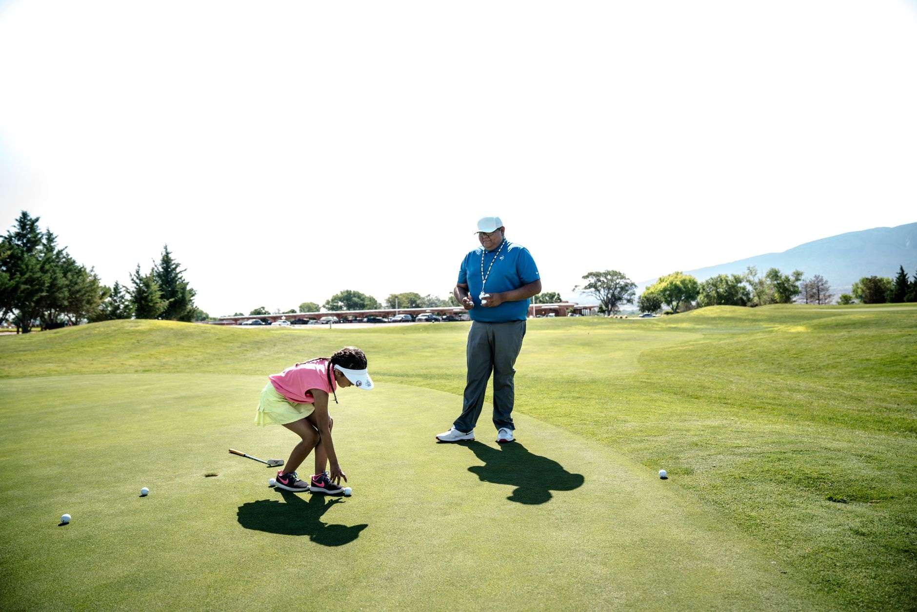 Children practicing short-game shots on a golf practice green