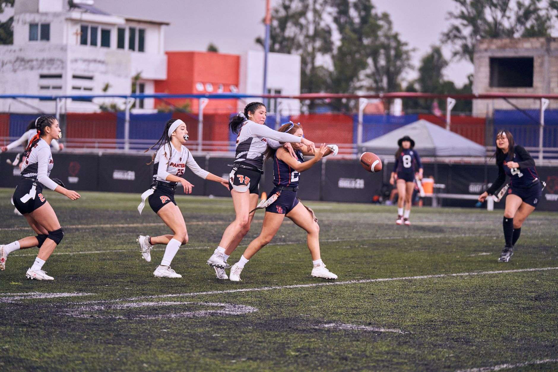 Players competing in a flag football game on a grass field
