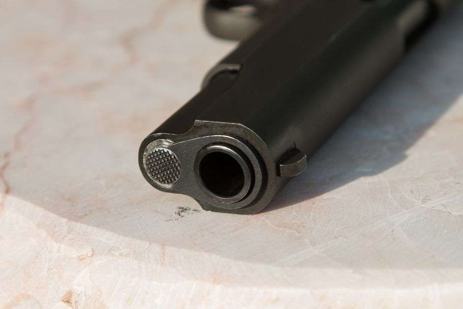 Close-up view of a semi-automatic handgun resting on a surface