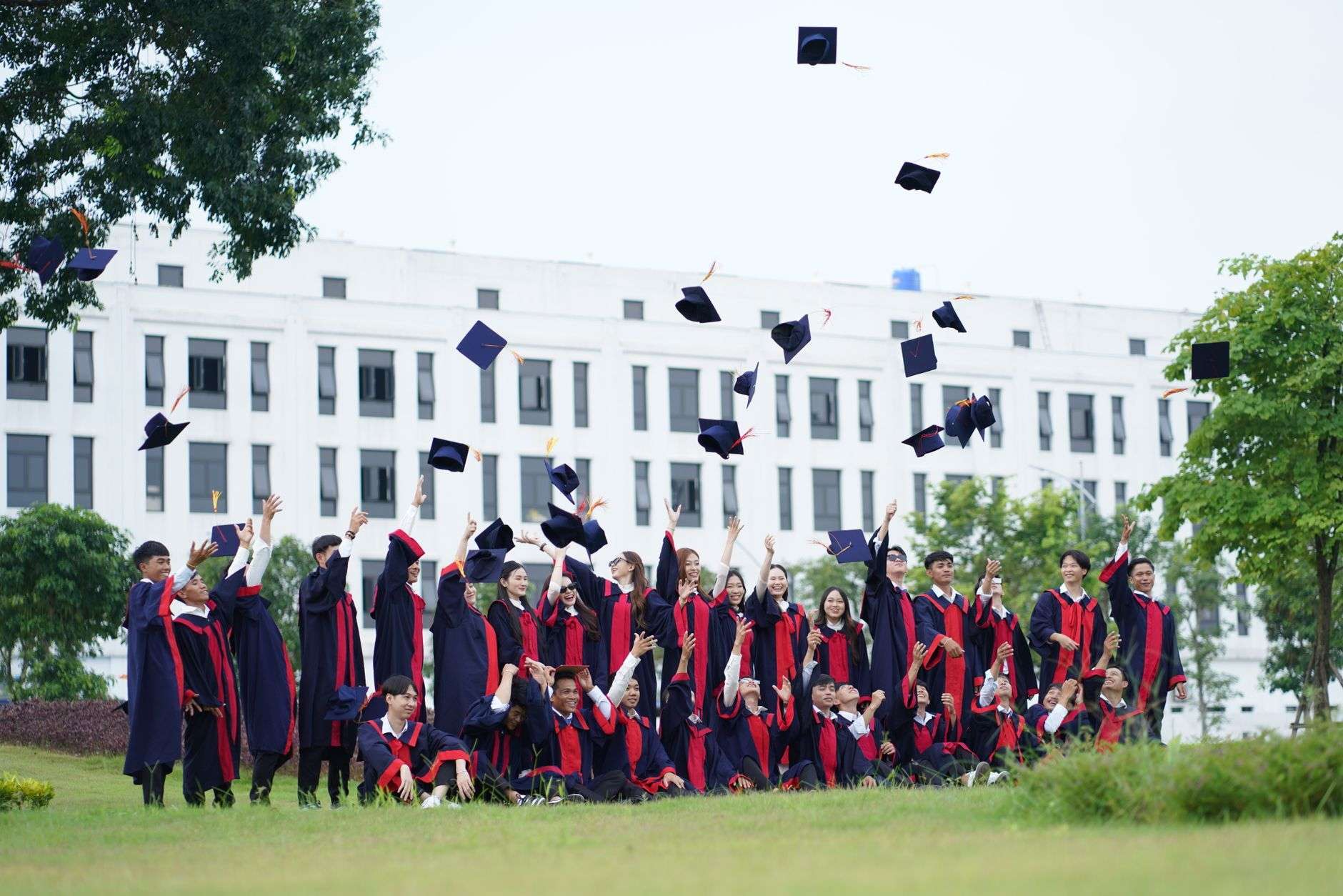 A group of graduates celebrate by throwing caps into the air