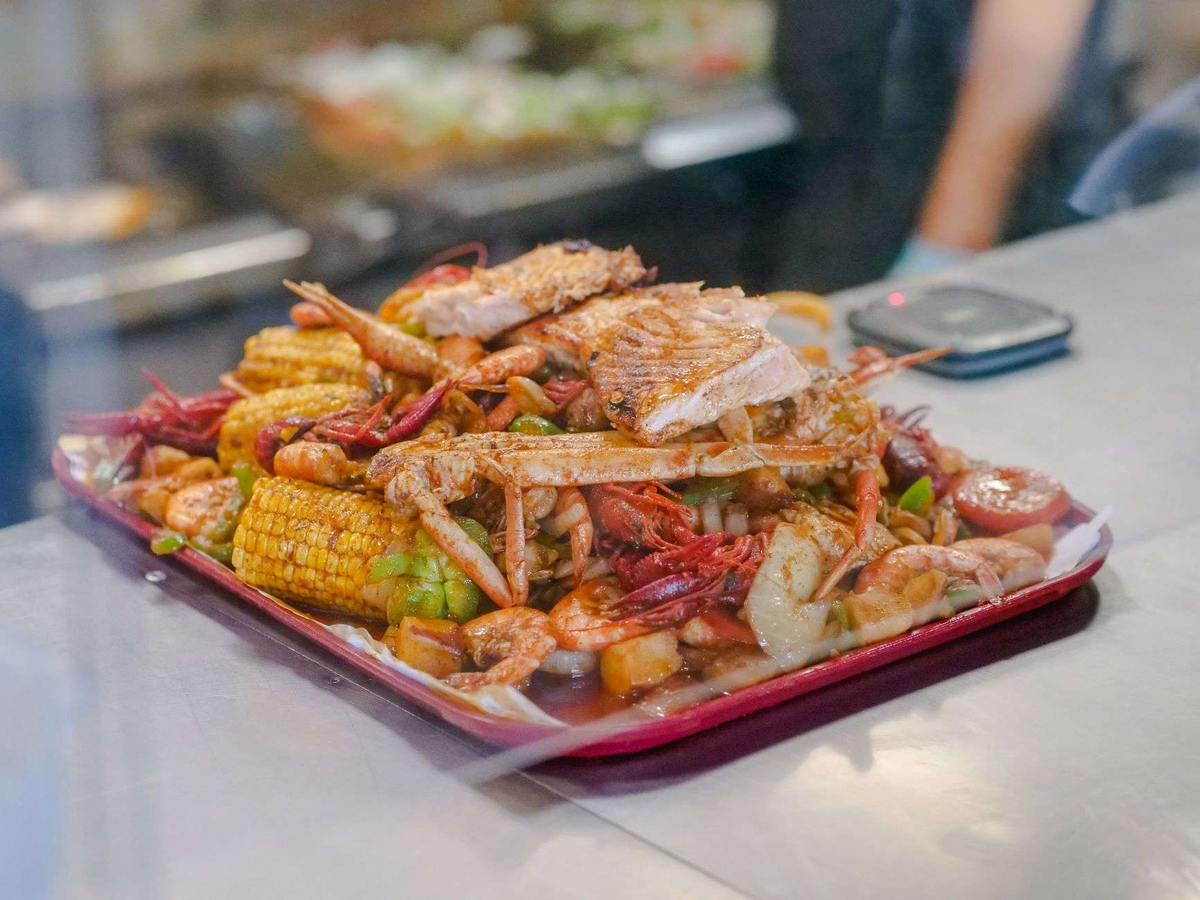 A seafood boil spread on a communal table, illustrating a community fundraising dinner