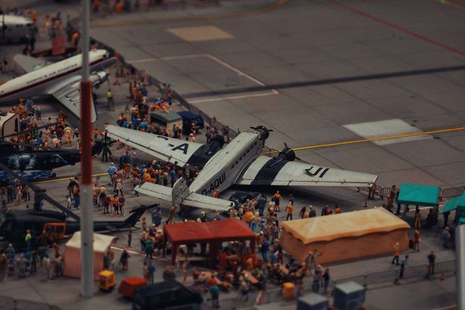 A small aircraft parked on the apron outside an airport terminal