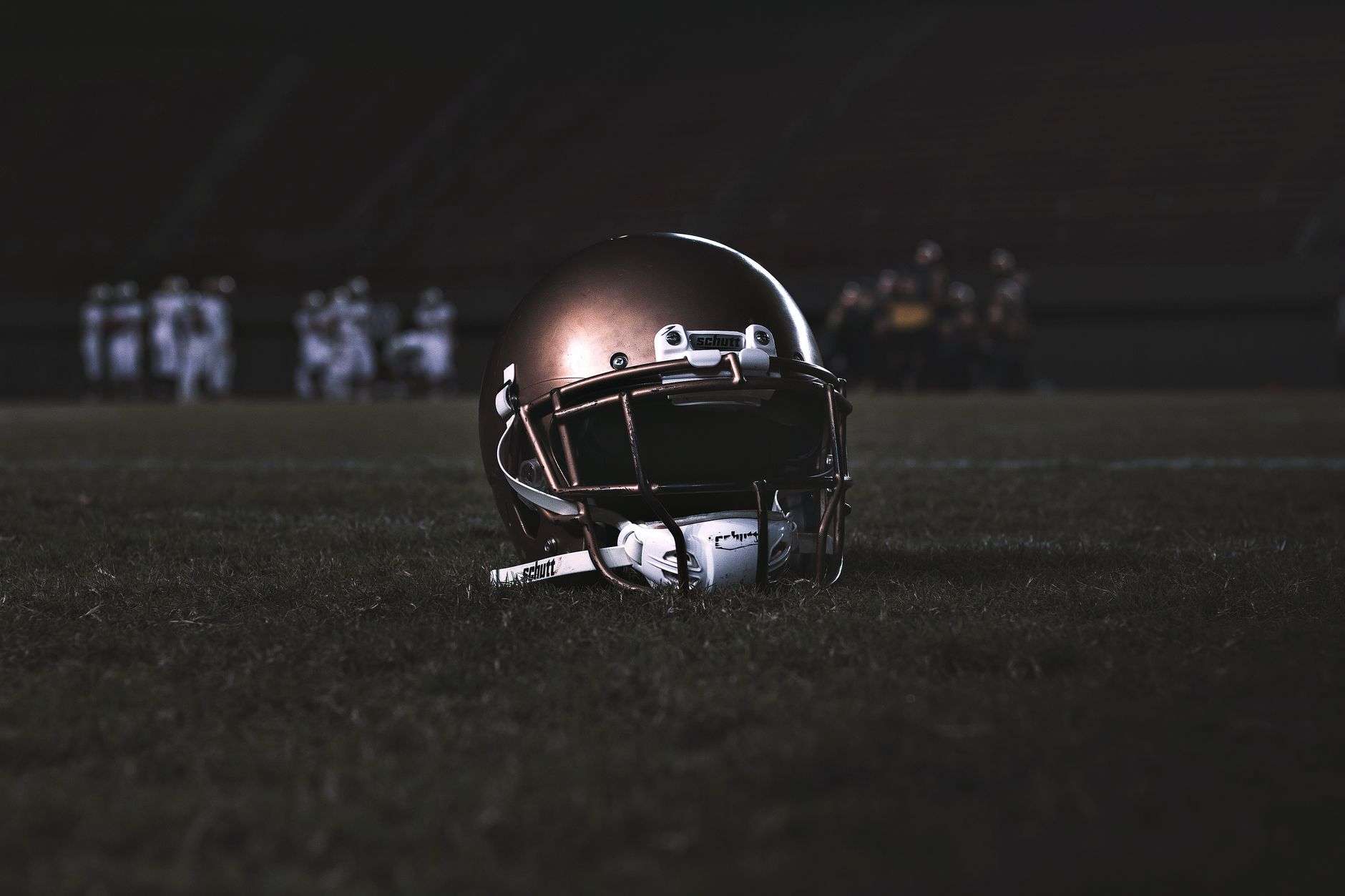 A football field illuminated by stadium lights during a night game