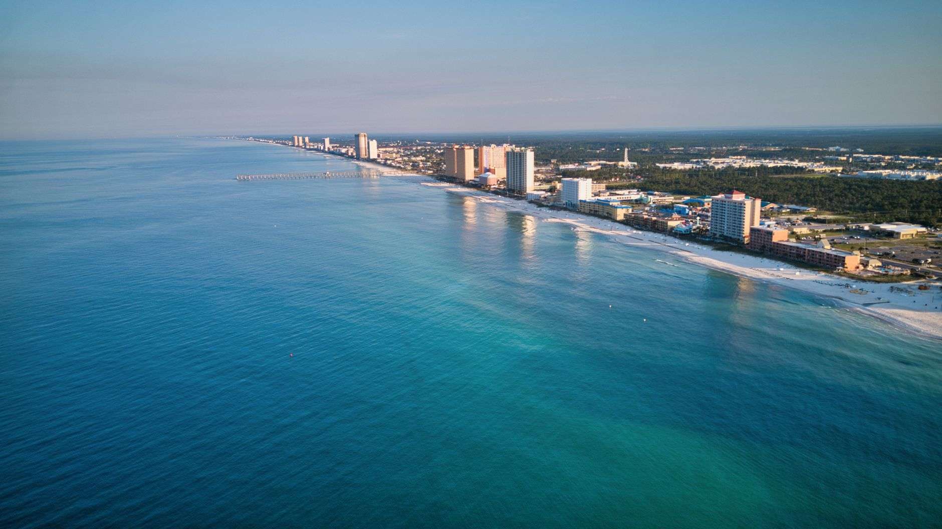 Beachfront condominium towers along a stretch of white sand coastline