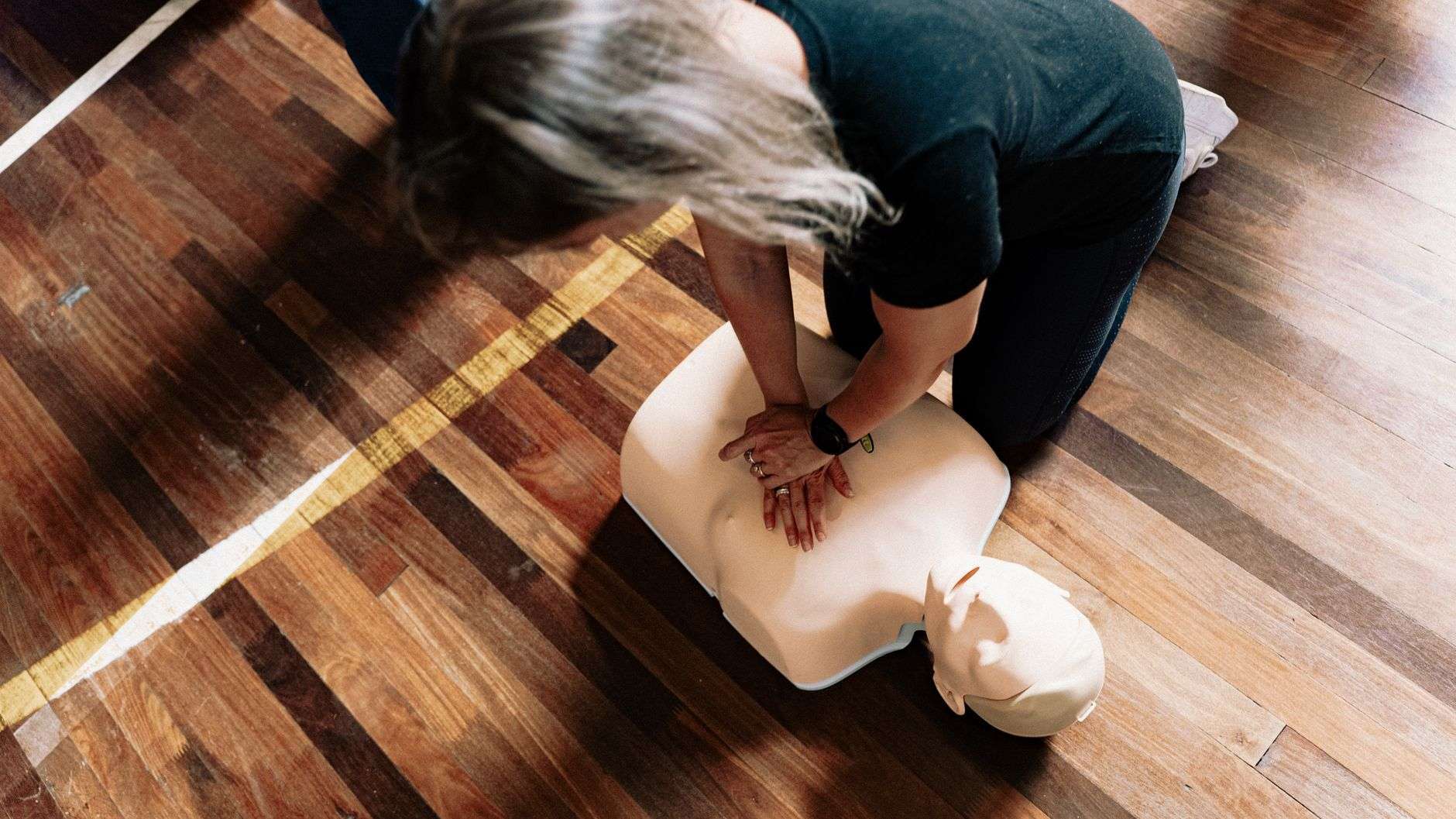 Hands performing chest compressions during CPR training