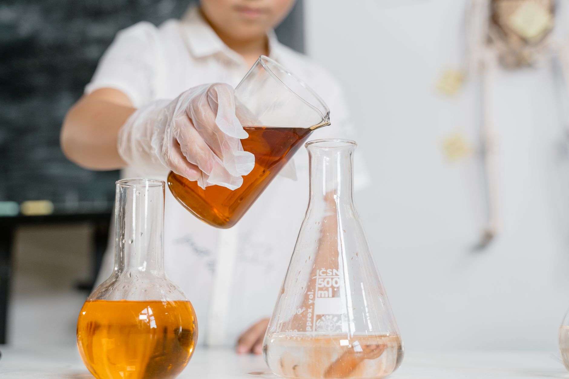 Laboratory glassware with colored liquids on a lab bench
