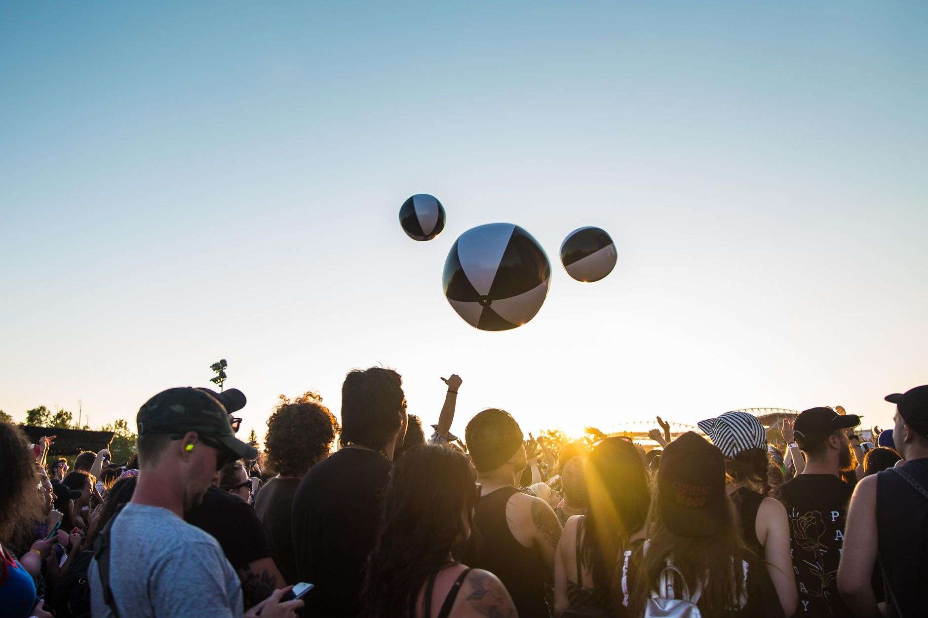 Crowd enjoying an outdoor concert as the sun sets