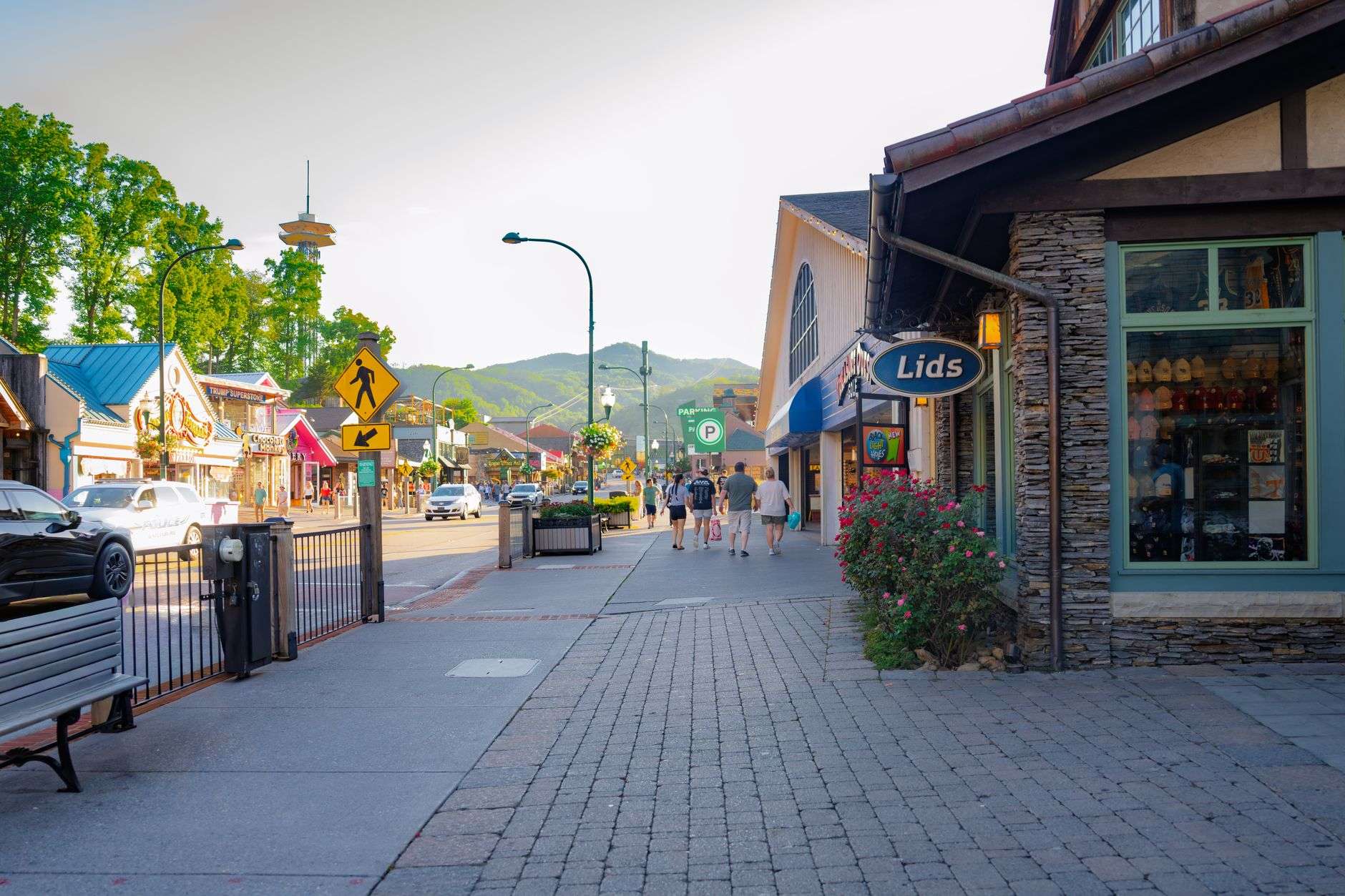 Pedestrians and storefronts along a sidewalk in a small coastal business district