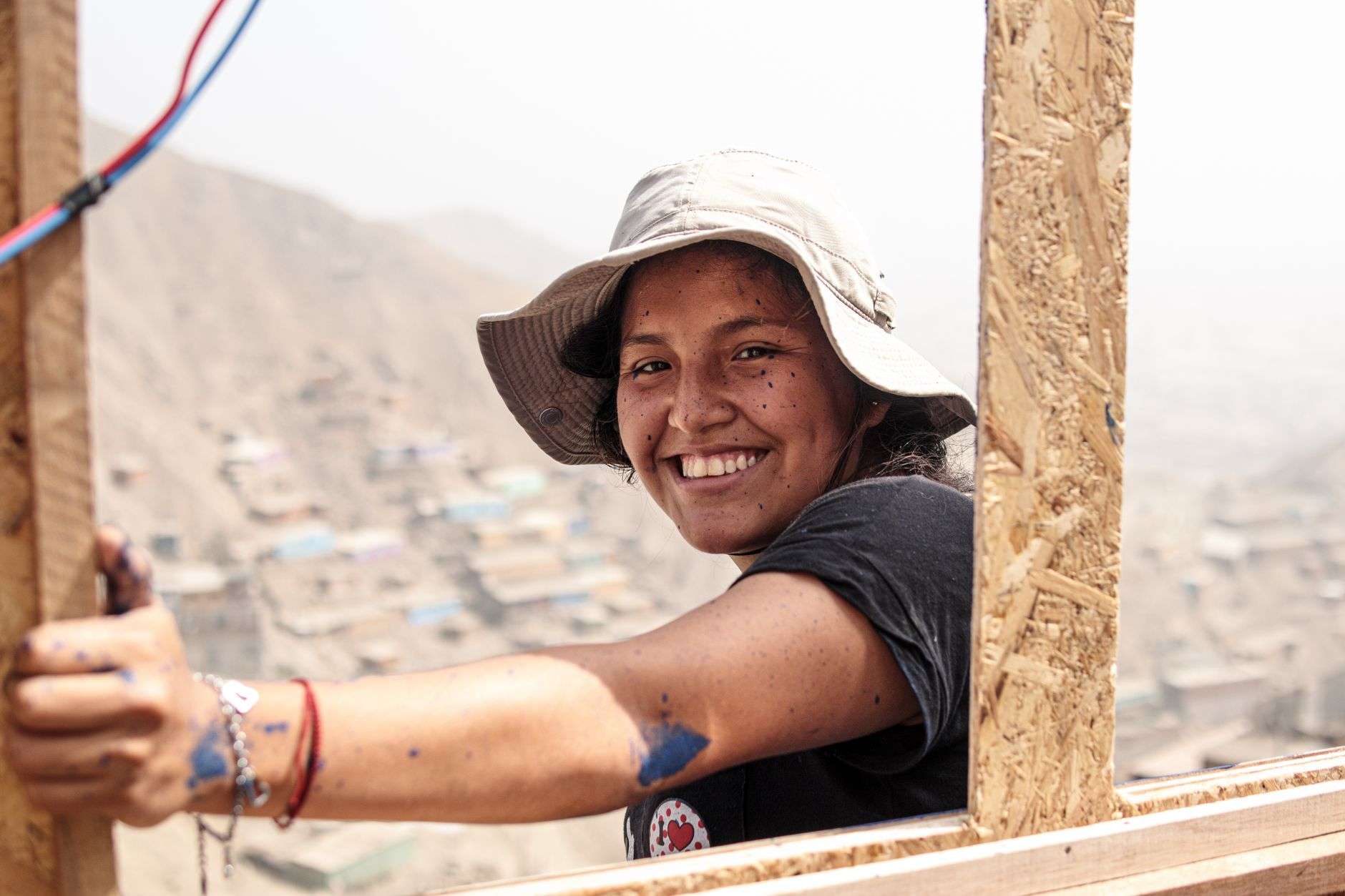 Cheerful woman with paint stains at a construction site