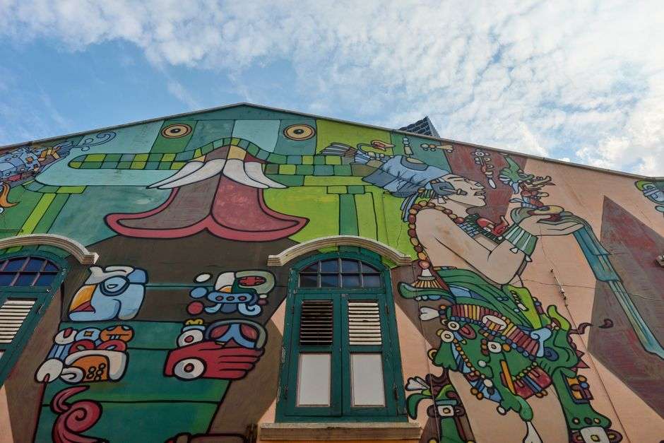 Brightly colored mural covering a brick wall in a downtown alley