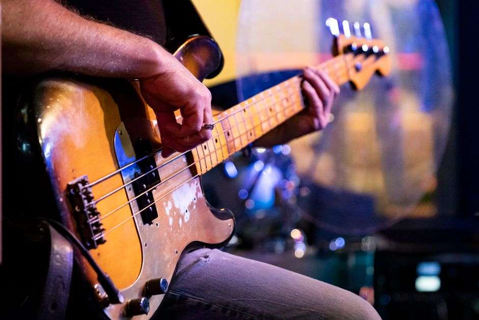 Bassist playing an electric bass guitar during a live rock show