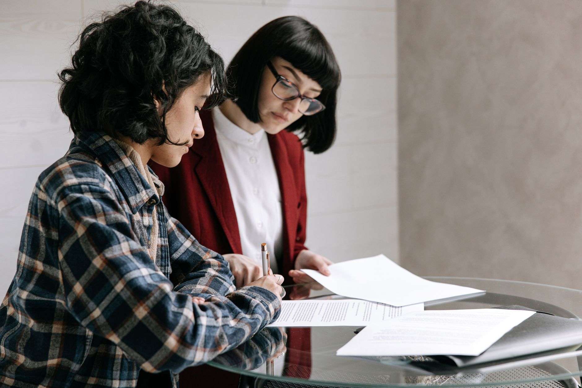 Person reviewing and signing documents at a desk