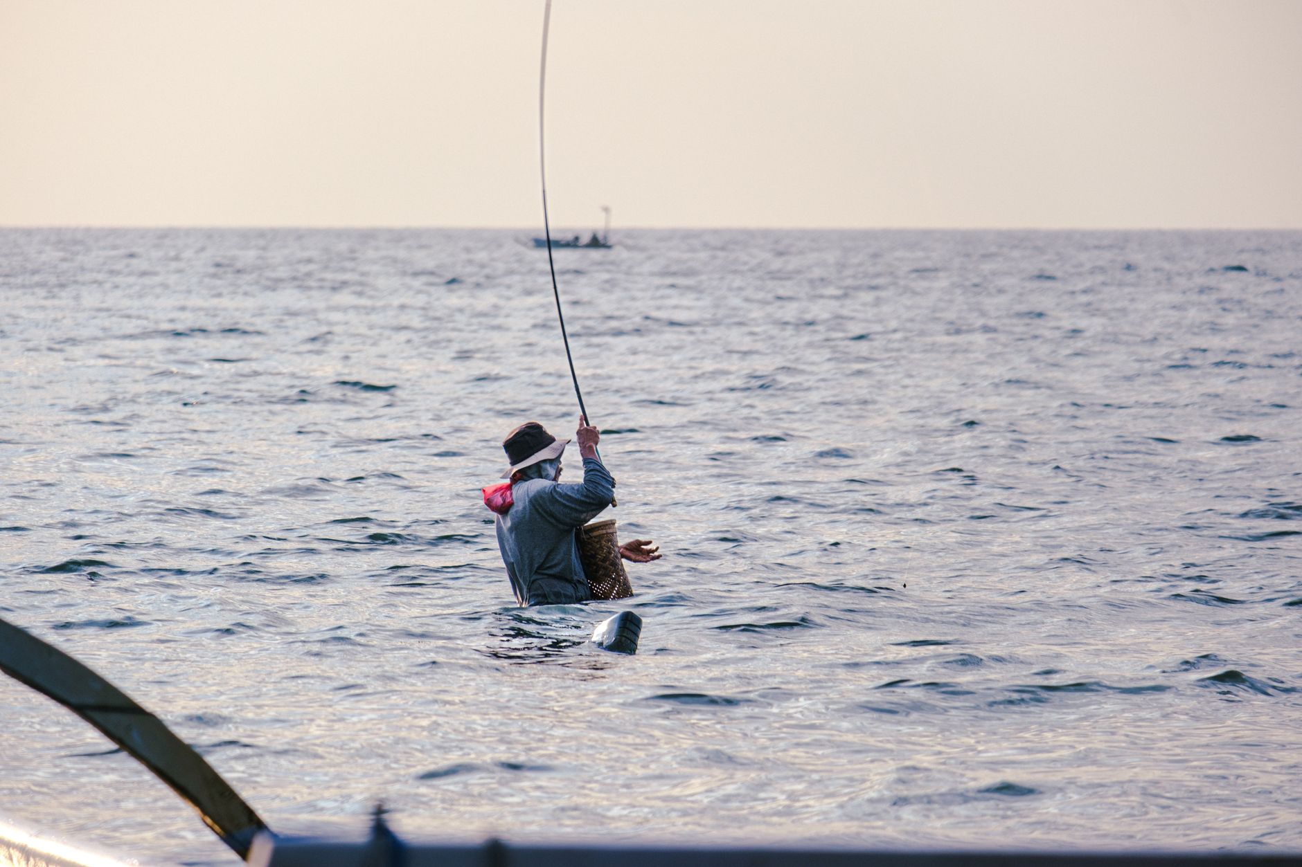 Fly angler casting a line over calm coastal water