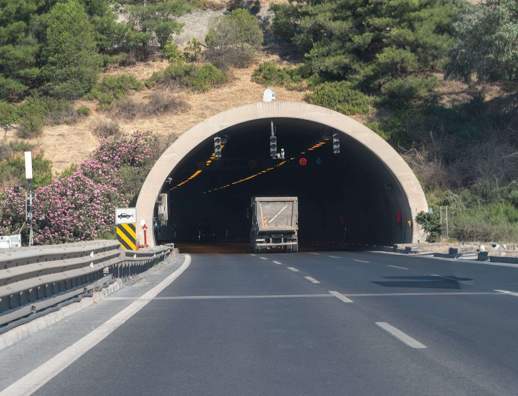 Vehicles traveling on an interstate highway approaching a tunnel entrance