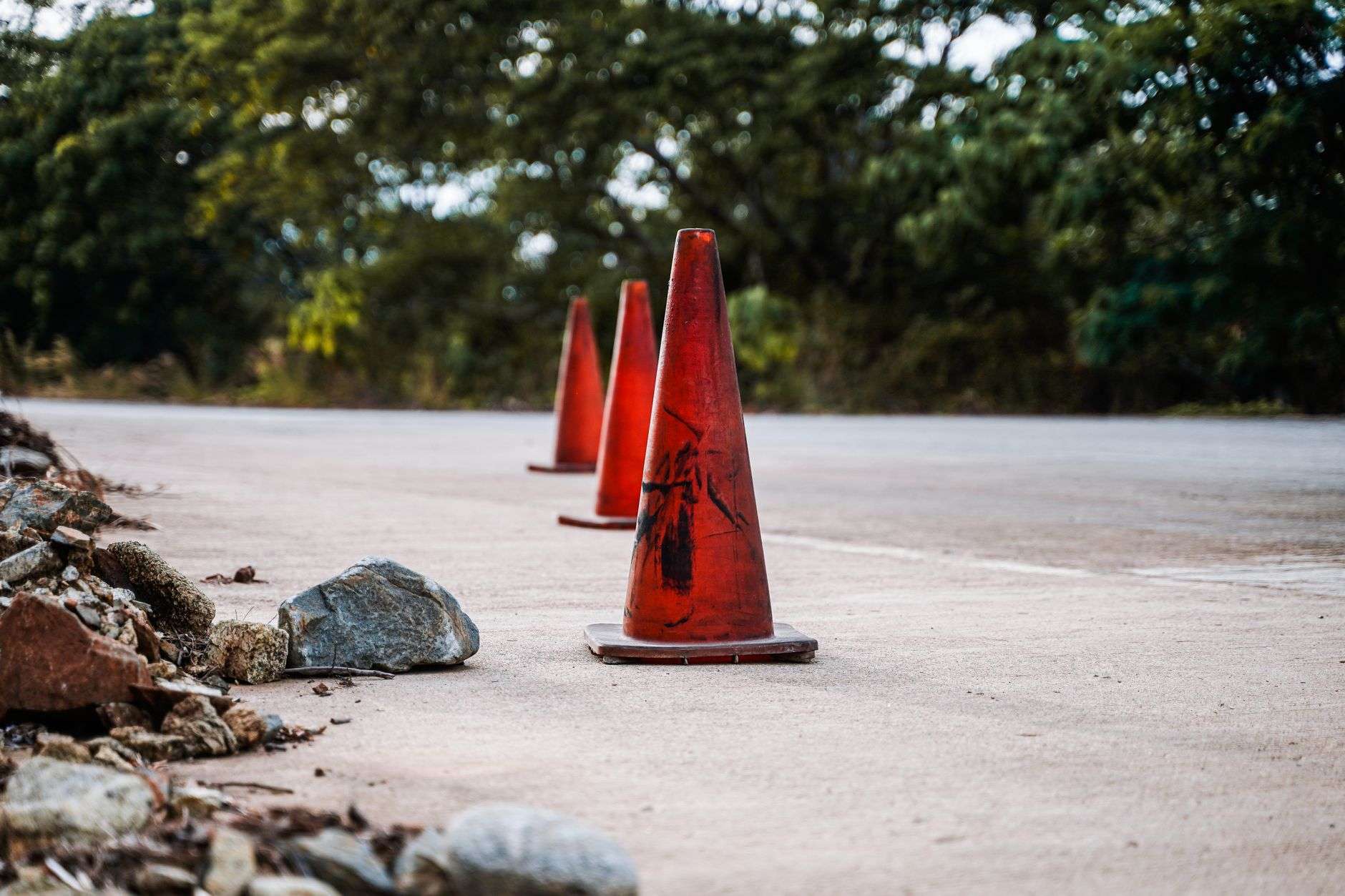 Orange traffic cones marking a lane closure in a highway work zone
