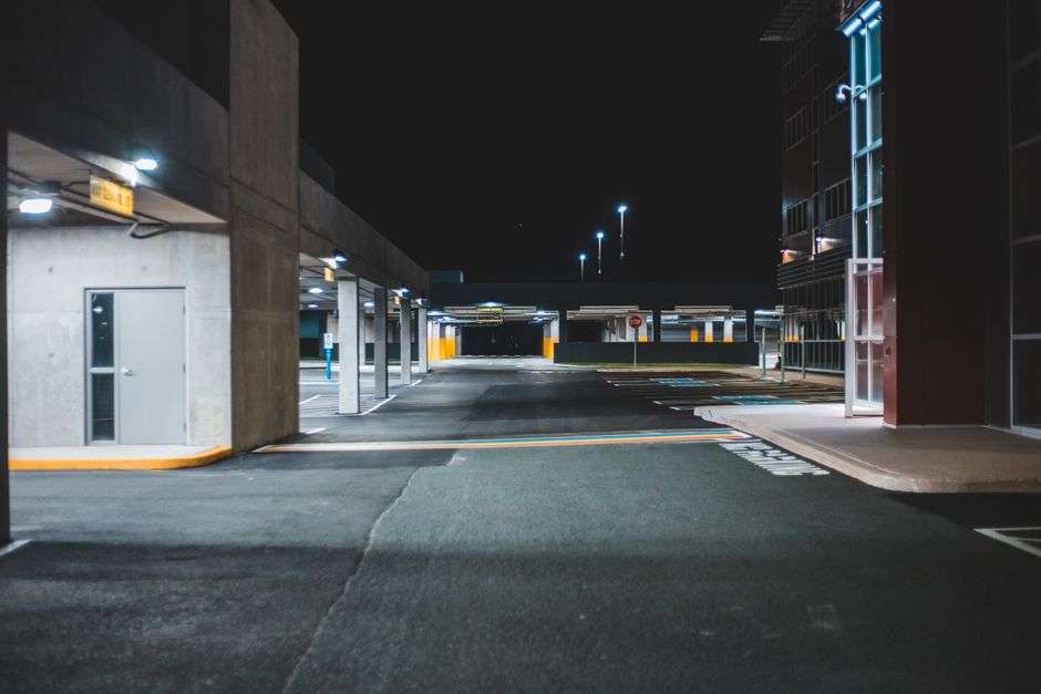 A dimly lit apartment complex and parking lot at night