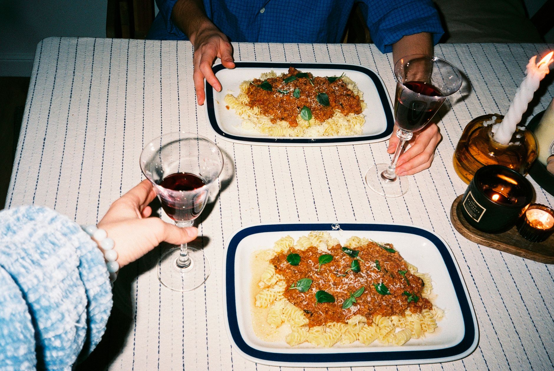 Plates of pasta on a table in a small, warmly lit Italian restaurant