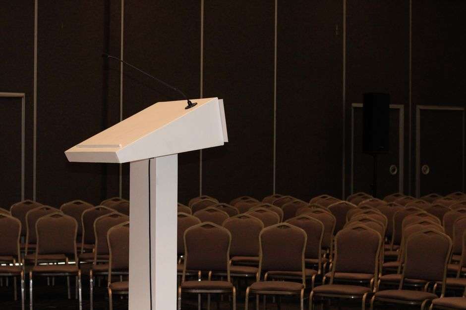 An empty podium with a microphone on a debate stage