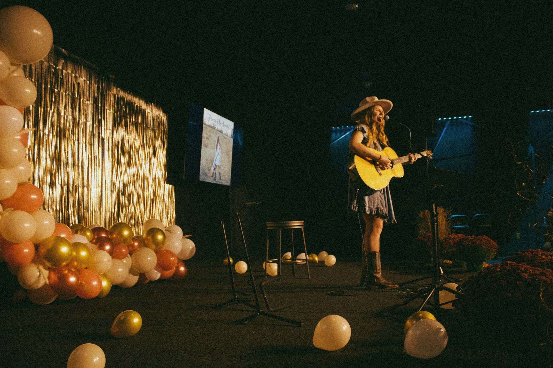 An acoustic guitar on a stage under warm lights, representing Gulf Coast musicians honored at the Josie Music Awards