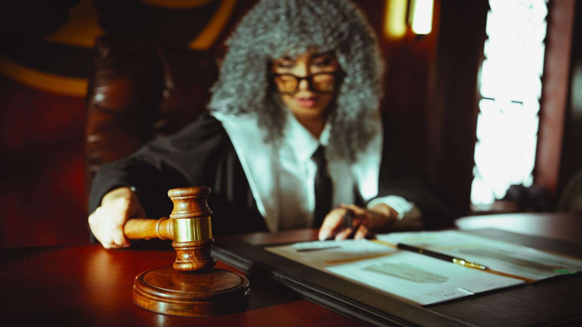 An empty courtroom with a judge's bench, witness stand and wooden benches
