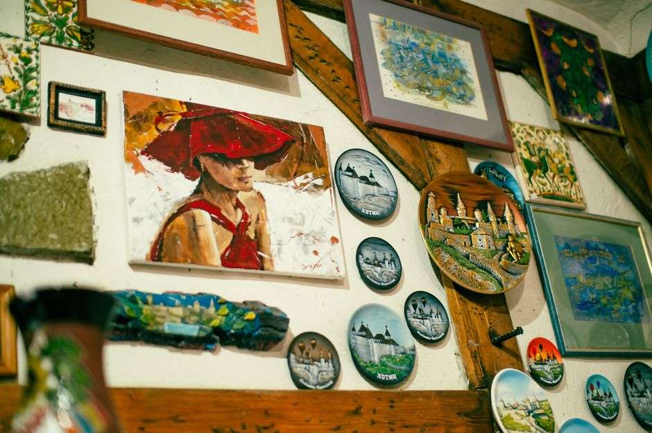 Framed paintings displayed along the white walls of a bright art gallery interior