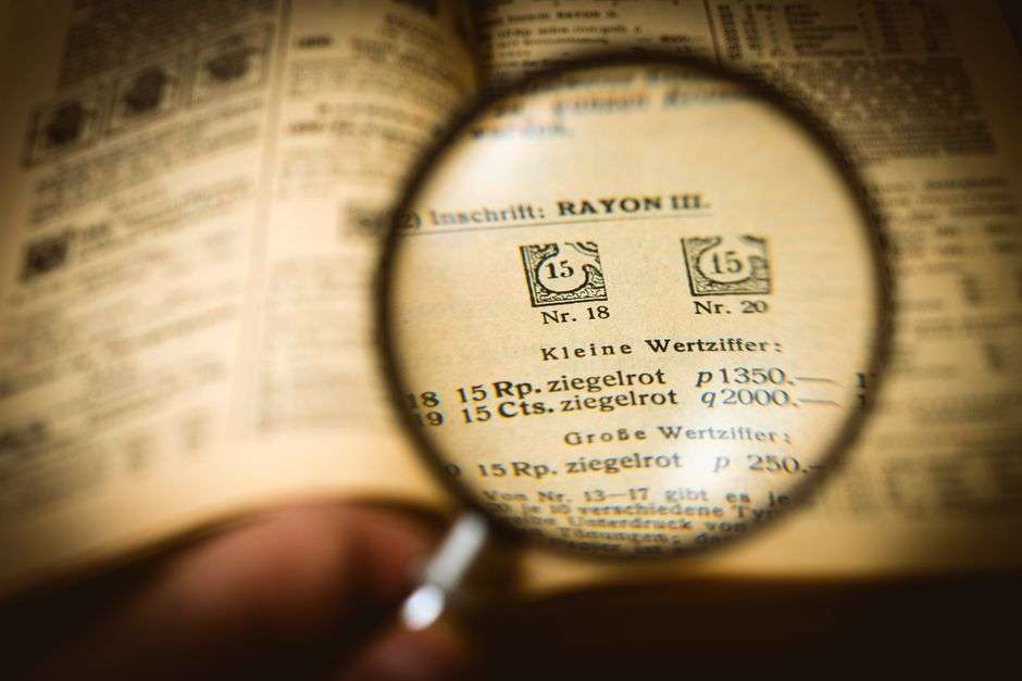 A magnifying glass lying on top of scattered paper documents