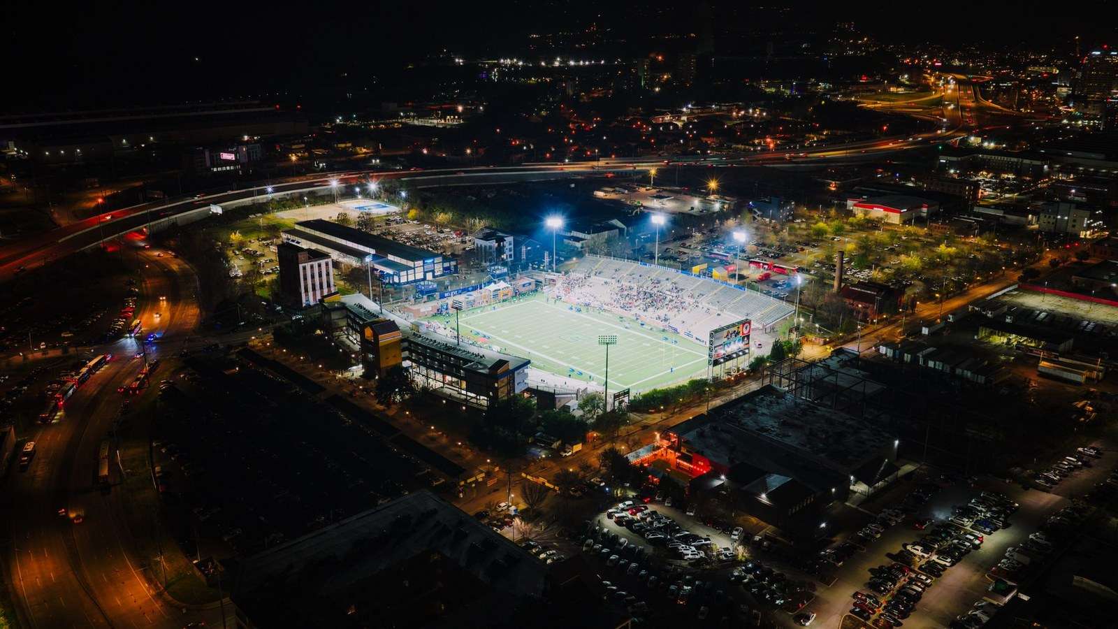 Stadium floodlights illuminating an empty American football field at night