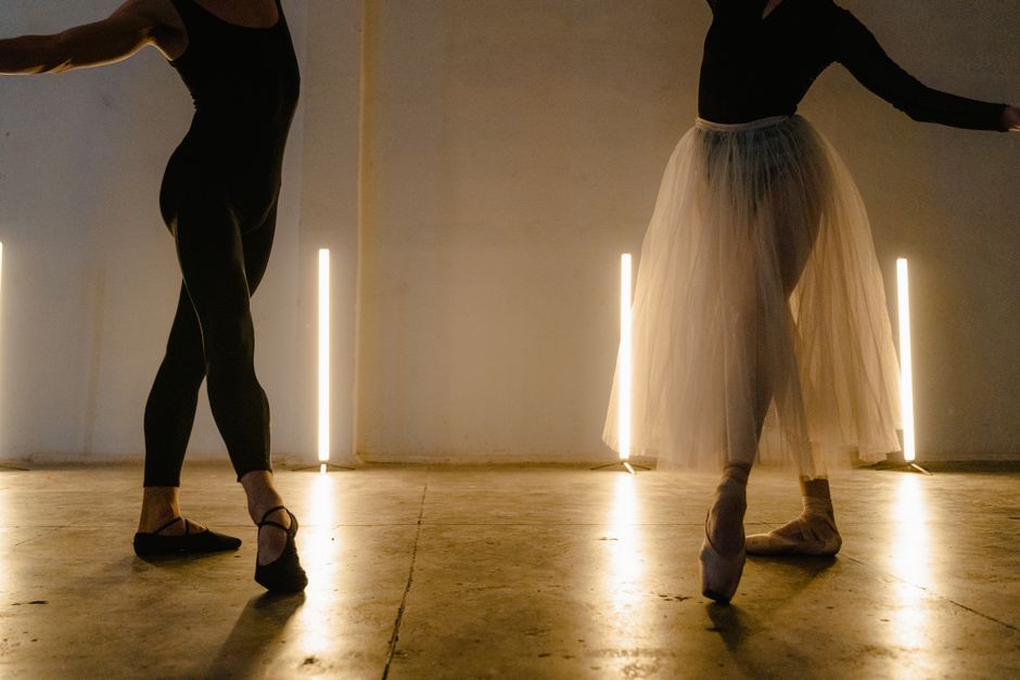 Ballet dancers rehearsing at the barre in a bright dance studio