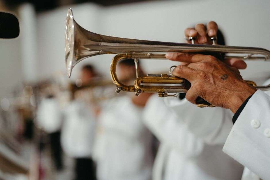 Big band orchestra performing on stage with trumpets and saxophones