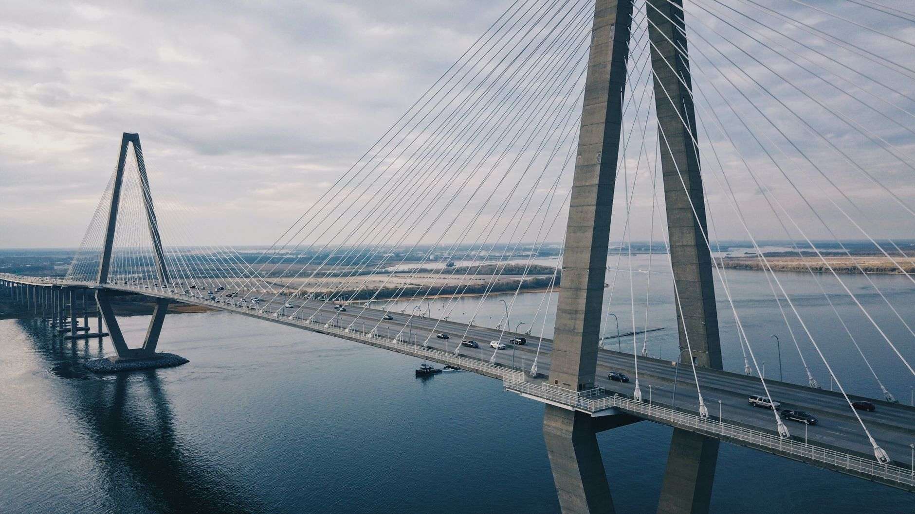 Cable-stayed highway bridge spanning a river under a clear blue sky