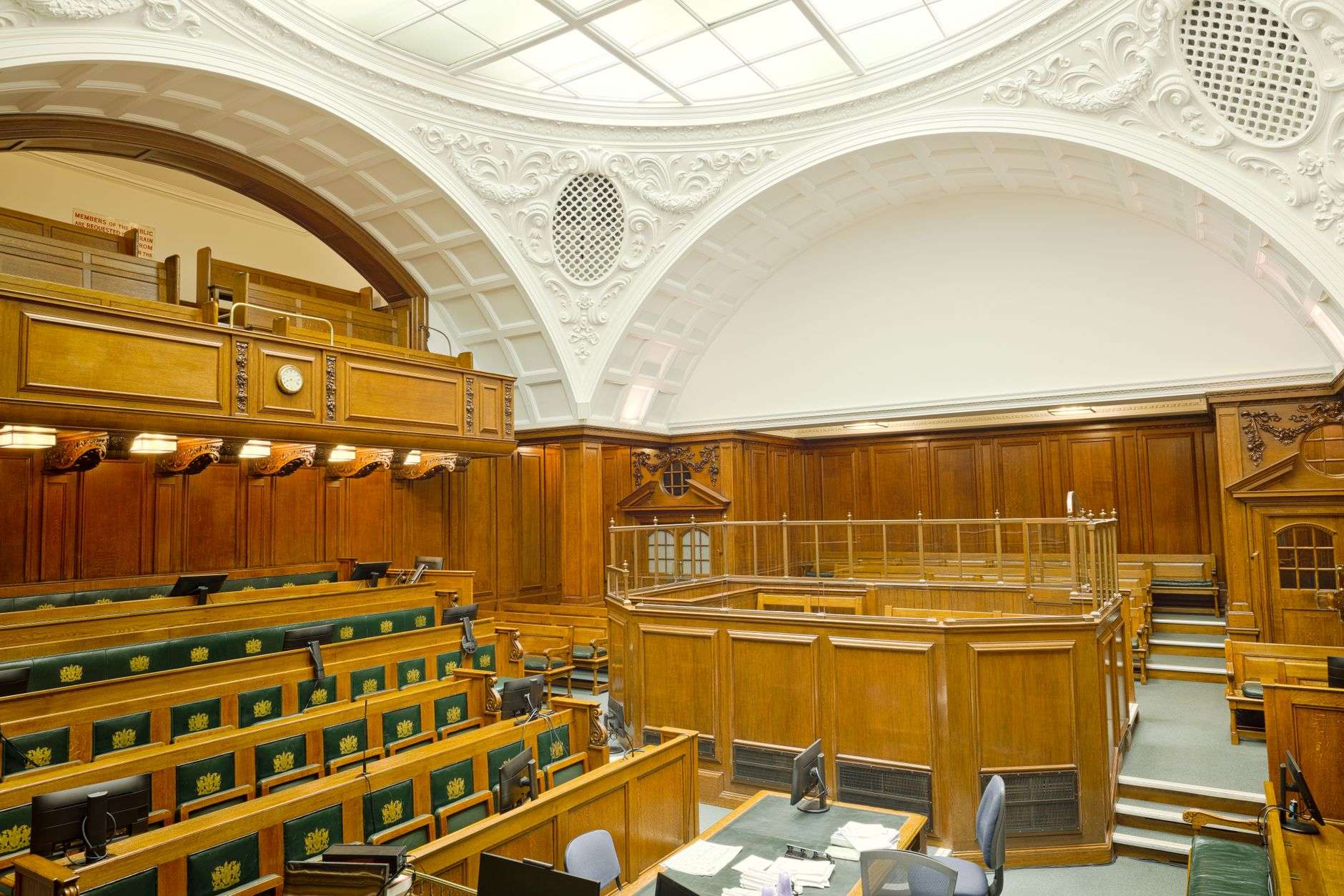 Historic courtroom with wooden benches and a railed balcony