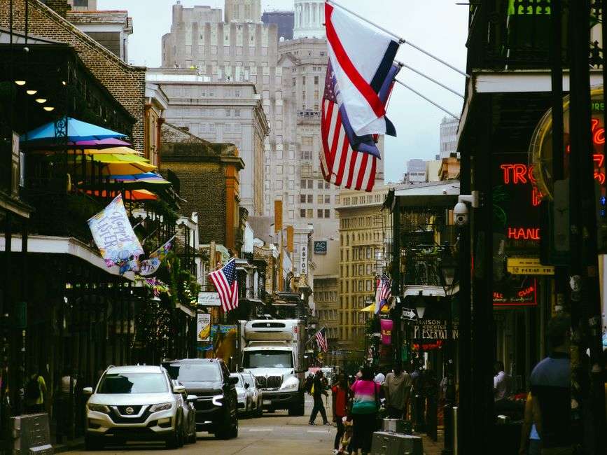 Historic buildings and neon signs along a French Quarter street in New Orleans