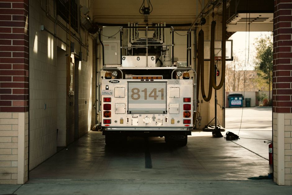 A red fire engine parked outside a fire station bay