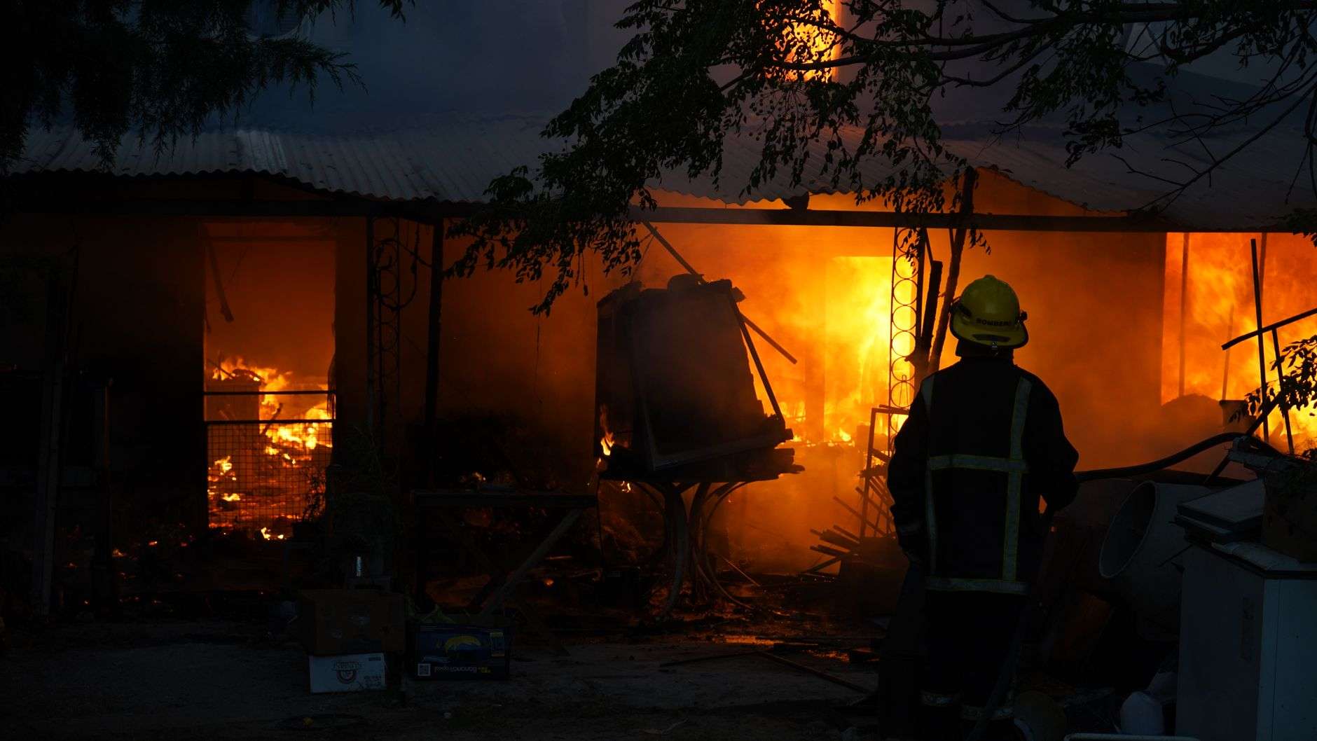 Firefighters working to put out a house fire at night