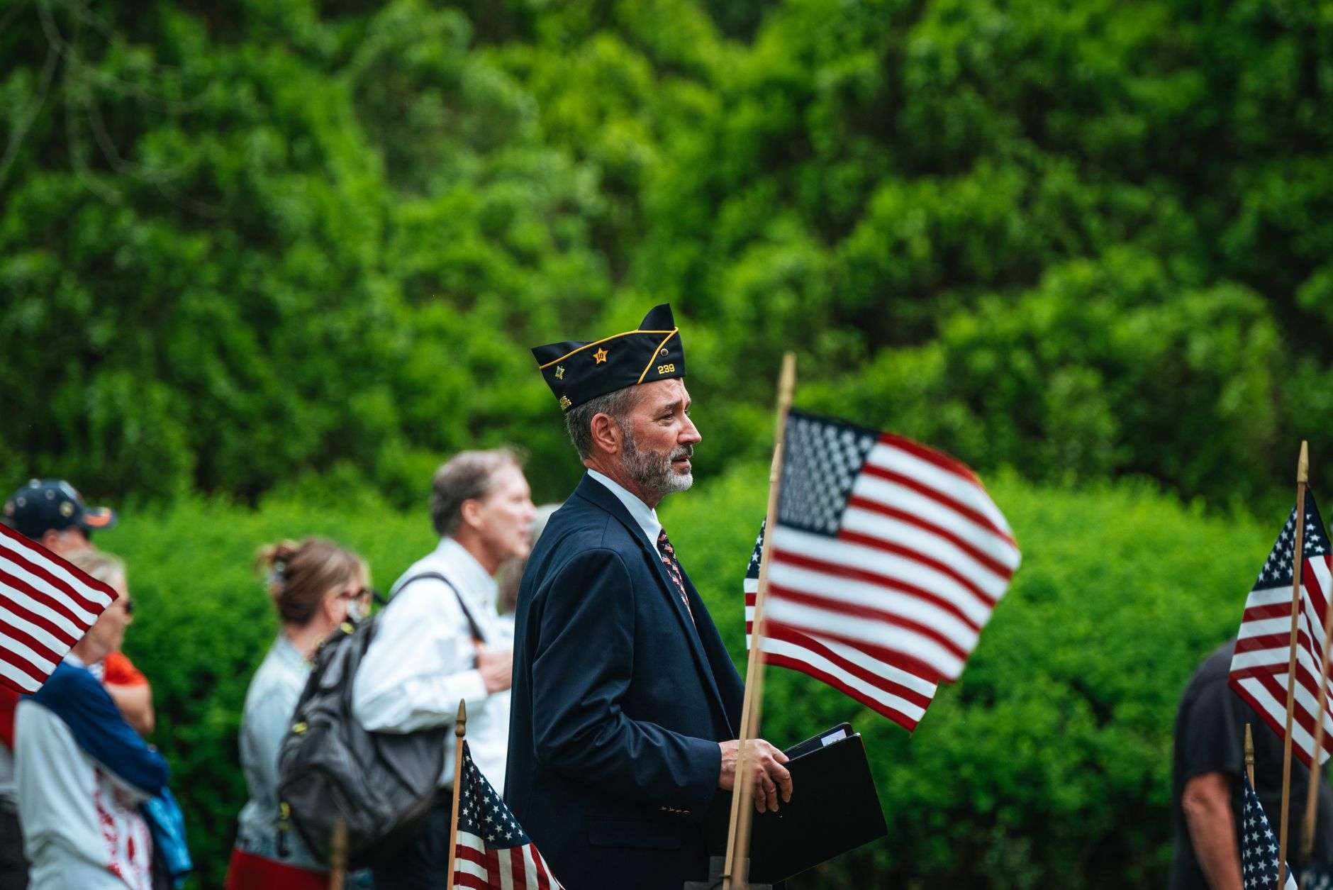 A veteran leads a patriotic parade surrounded by American flags