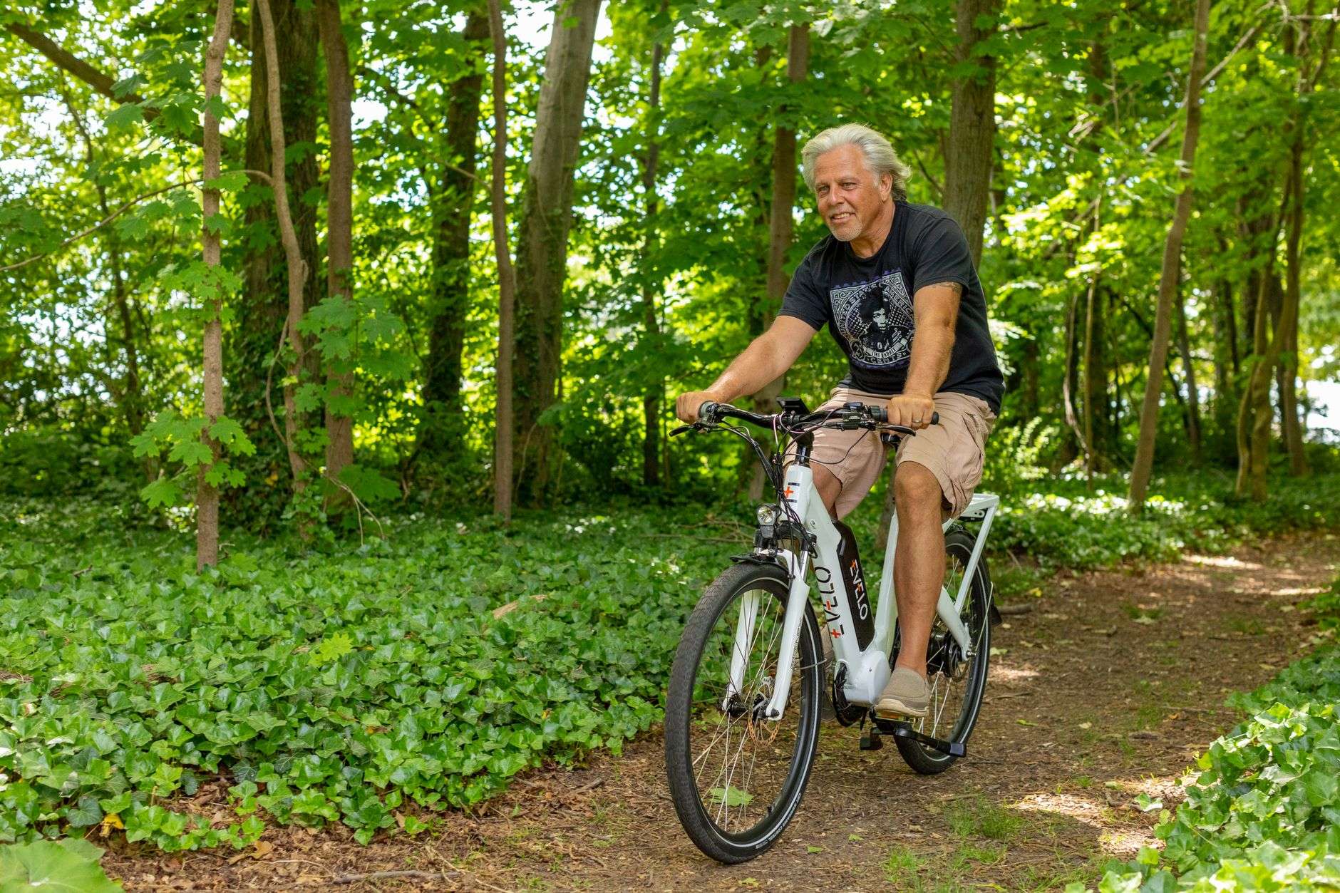 A rider on an electric bicycle traveling along a shared-use path