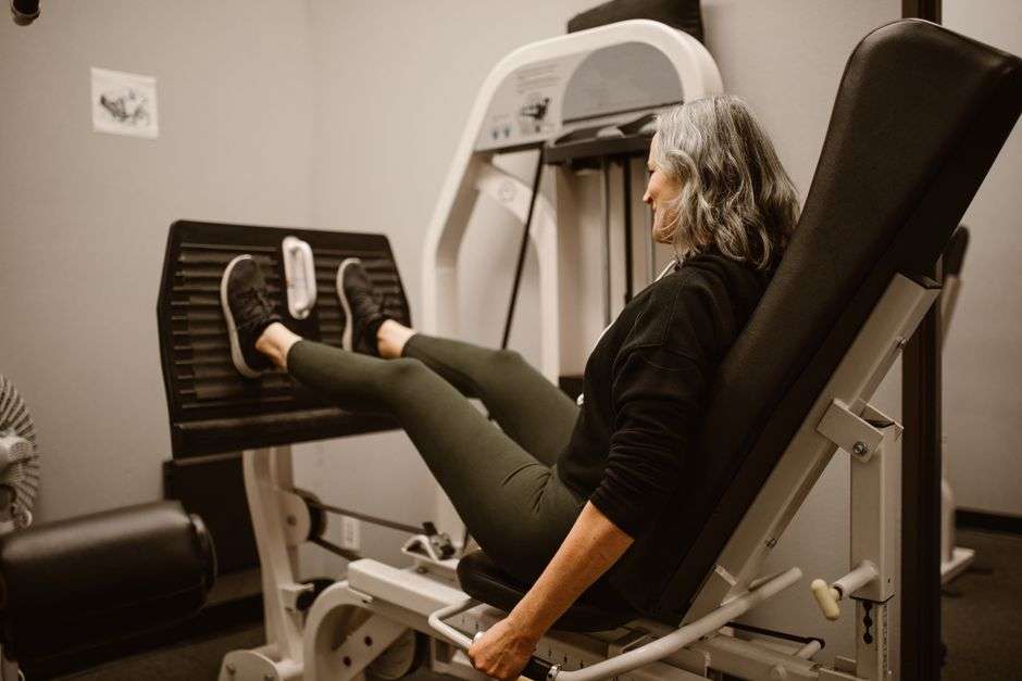 A member using strength training equipment at a wellness studio