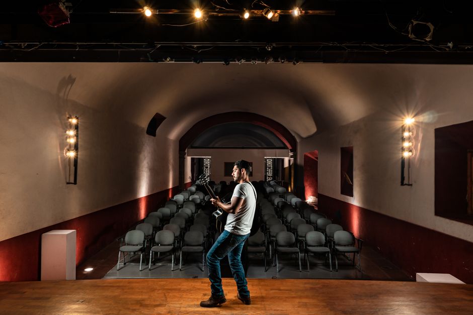 A small theater stage lit for an intimate concert performance