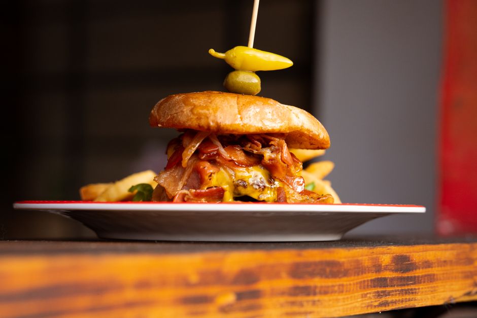 A cheeseburger with toppings served on a plate at a restaurant