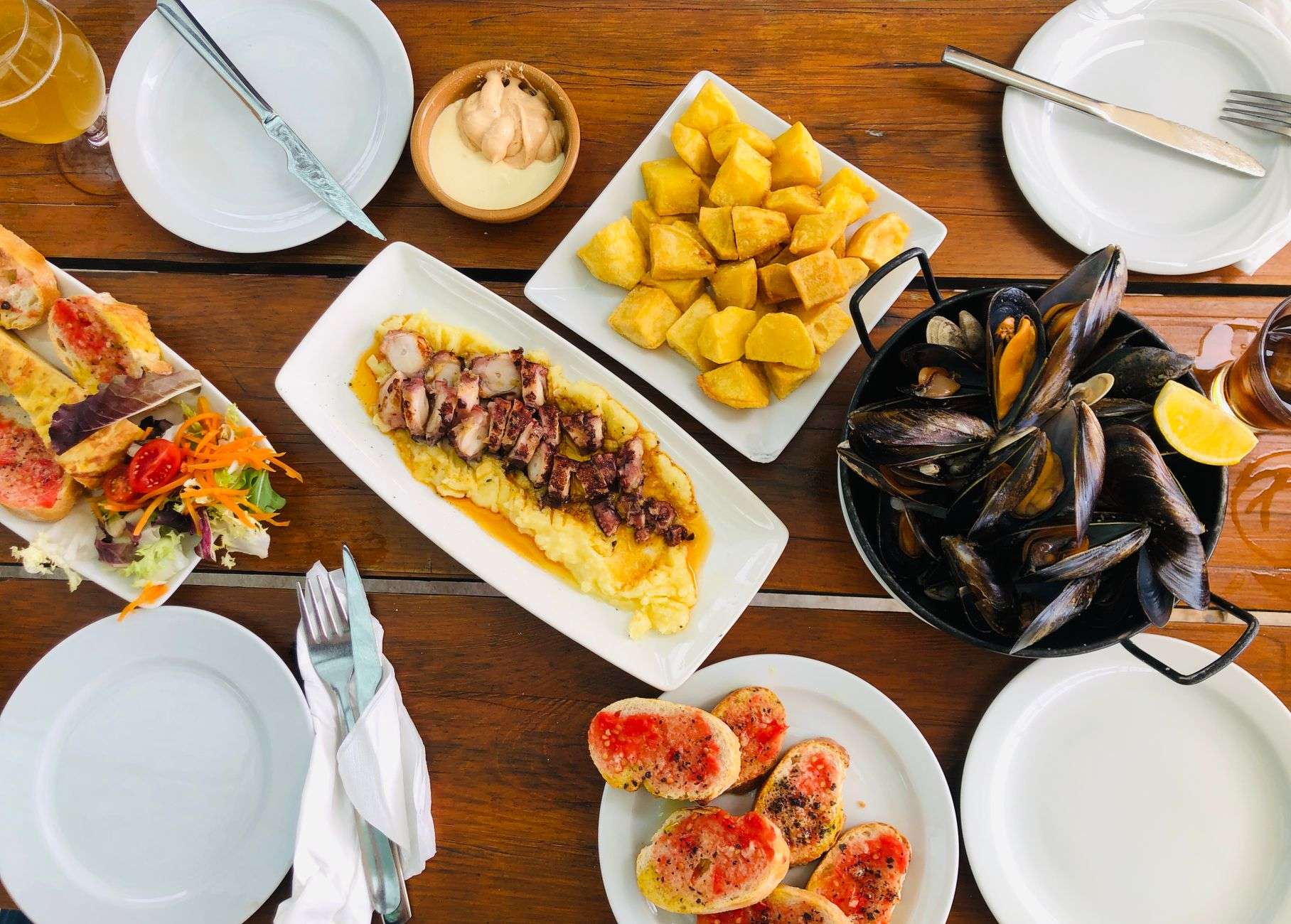Table of Spanish tapas with cured ham, cheese and glasses of red wine