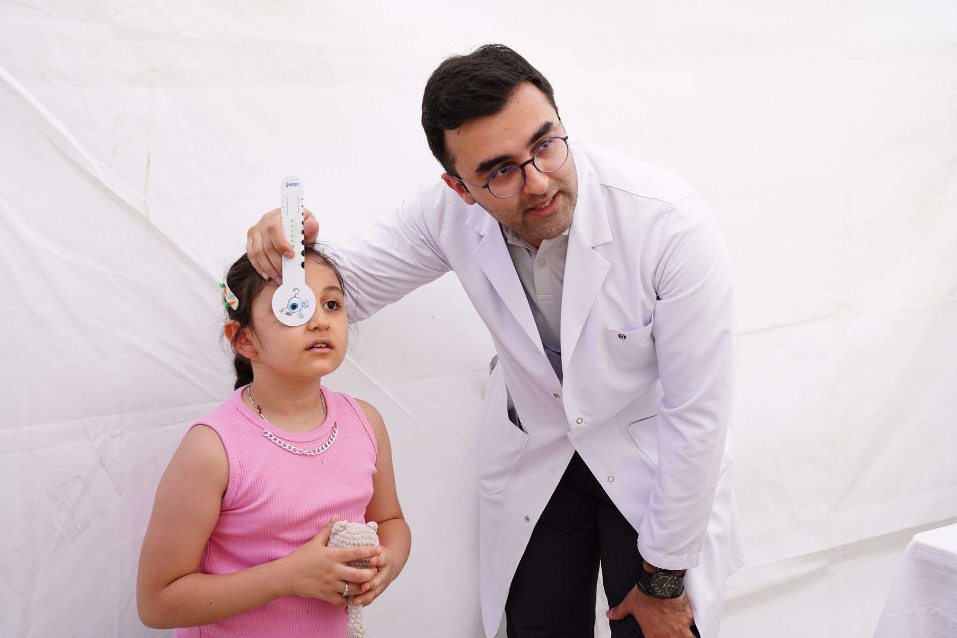 A health professional performing a screening check on a child