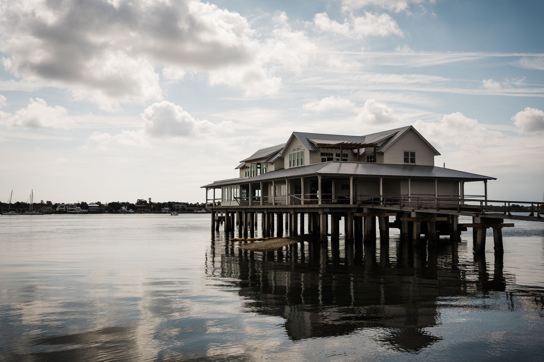 Bayfront house with a long wooden pier stretching over calm water