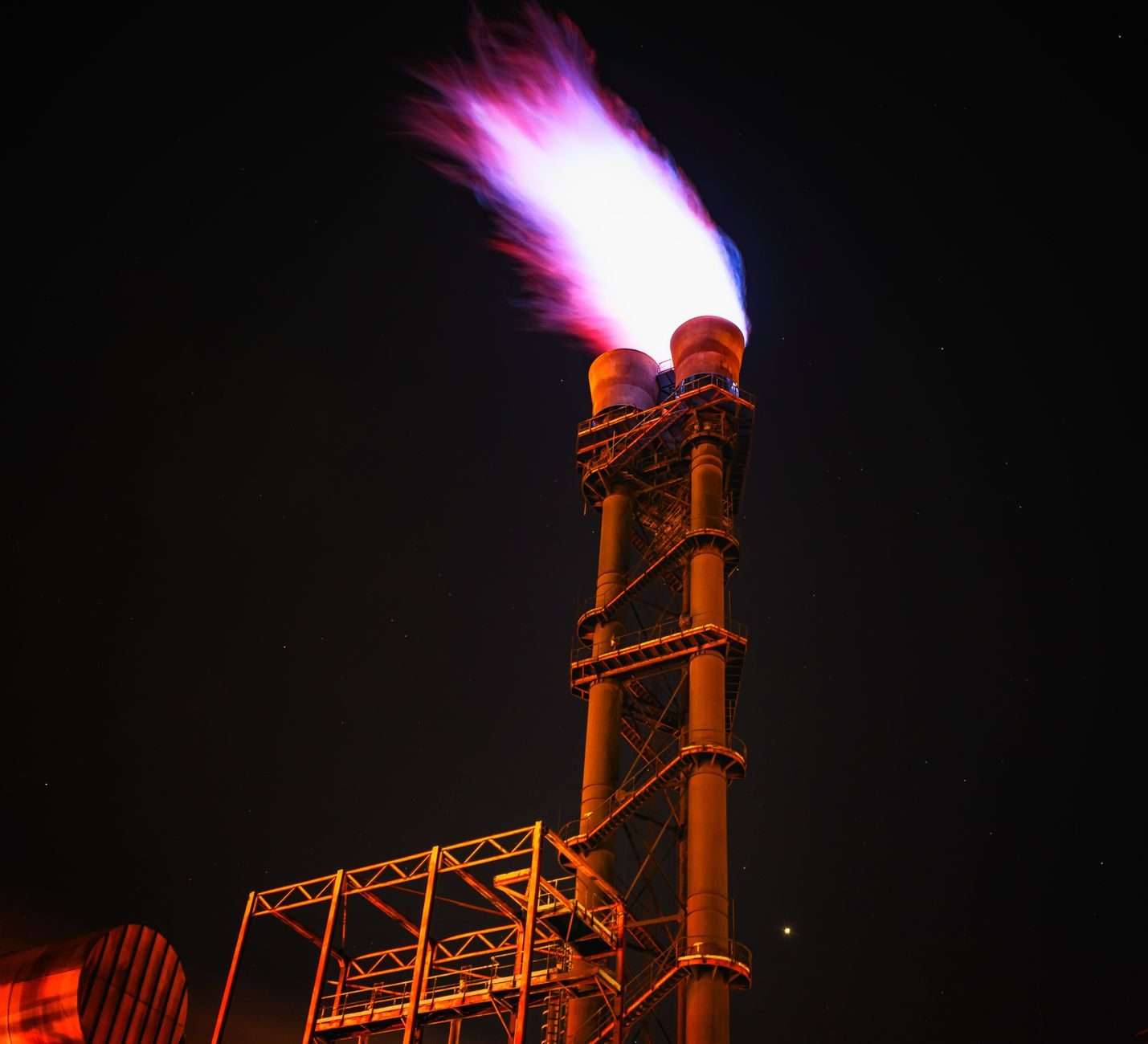 An industrial flare burning against a night sky