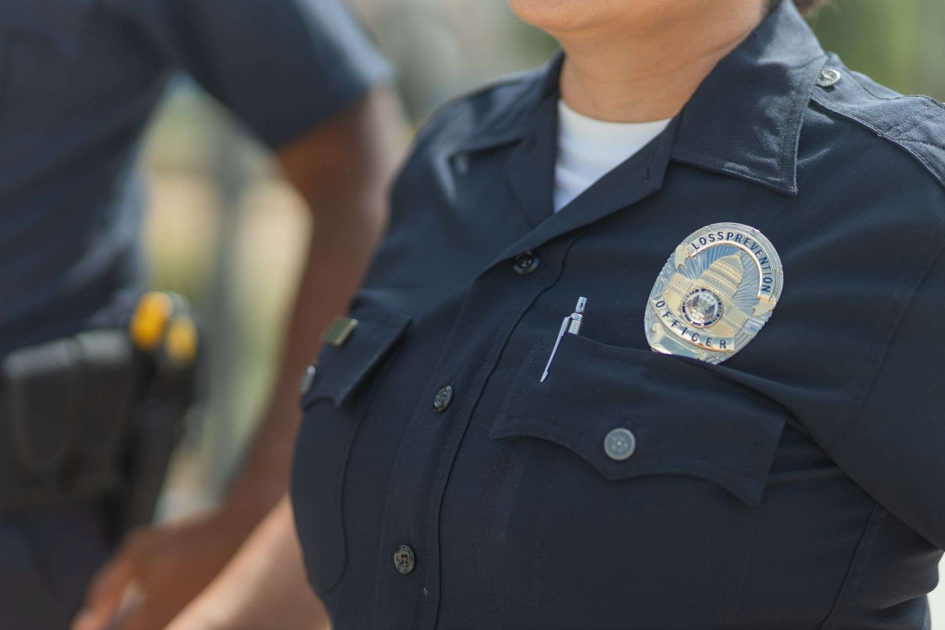 A close view of a police badge attached to a dark uniform shirt