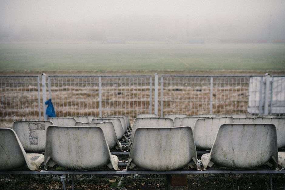 Empty weathered bleachers at an aging football stadium