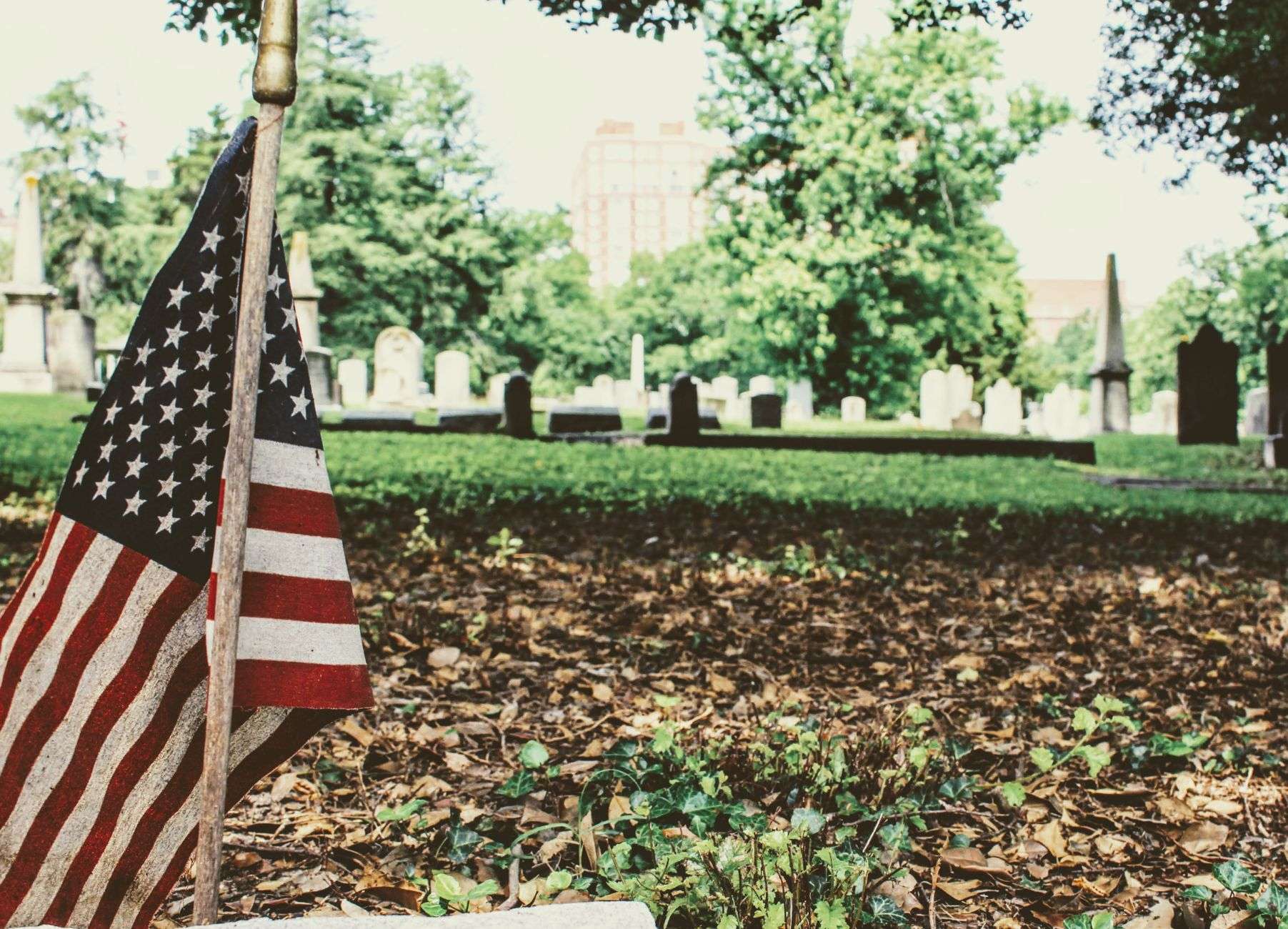 An American flag flying above a memorial park monument